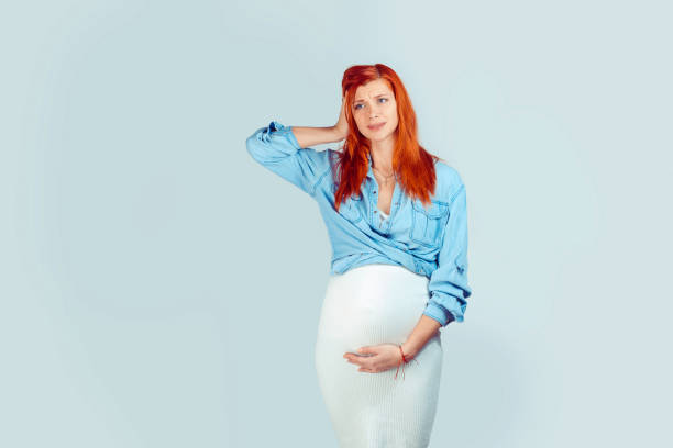 Upset pregnant model on blue stock photo