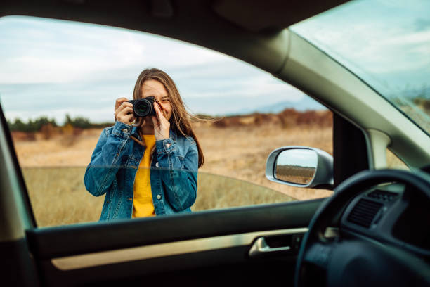Strike the pose! Woman is taking a photo of herself in the mirror of the car.