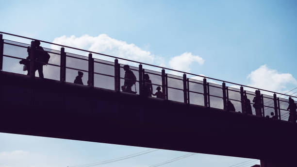 istock Pedestrian bridge and people 1130596047