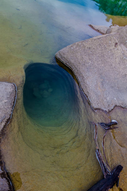 An Unusual Deep Rock Hole Formation Carved Smooth out of the Granite Bedrock by the Crystal Clear Blue-Green Waters of the Pedernales River.  At Pedernales State Park in Texas.