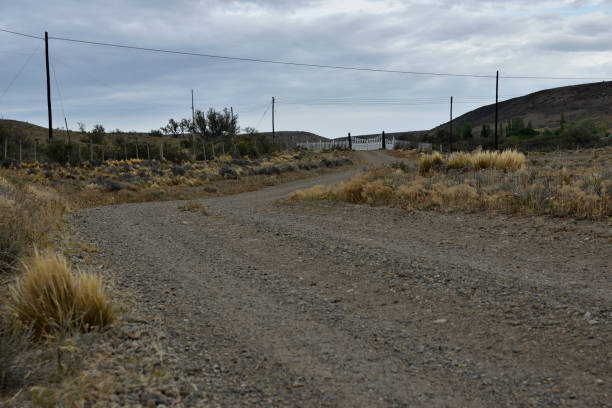 istock dirt road entering with gate and blue sky background 1130601055