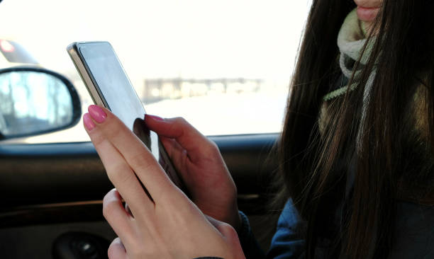 istock Close-up woman's hands chatting her cellphone sitting in the car. Side view. 1130601079