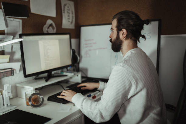 istock Young man working late in home office 1130605356