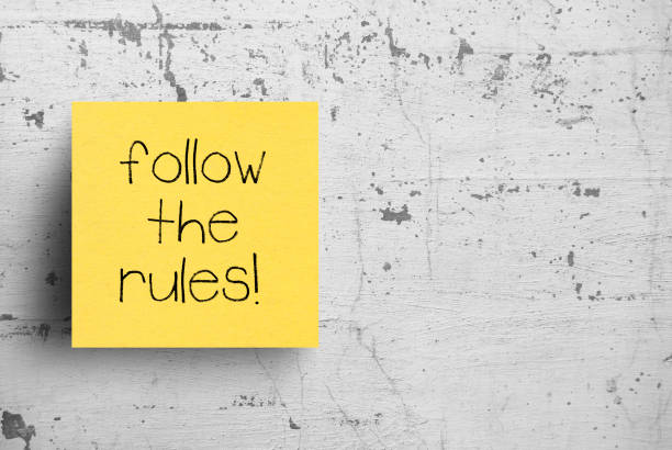 istock Sticky note on concrete wall, Follow the rules 1130610512