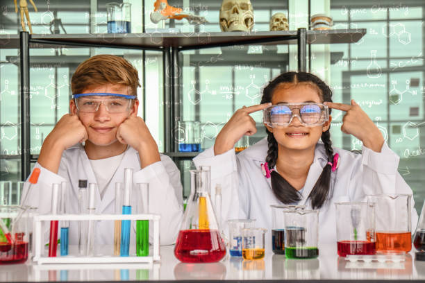 adolescente caucasico e adolescente asiatica in laboratorio con provetta - laboratory test tube student scientist foto e immagini stock