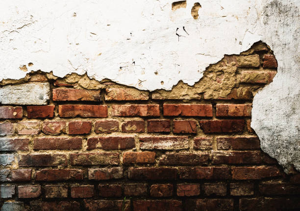 istock Brick wall with red brick and partially peeling white plaster 1130618659
