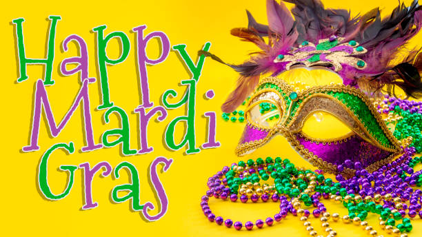 tema concetto di carnevale happy mardi gras and fat tuesday con primo piano su una maschera facciale piena di colore, piume e consistenza e perline dorate, verdi e viola isolate su sfondo giallo con testo - mardi gras new orleans mask bead foto e immagini stock