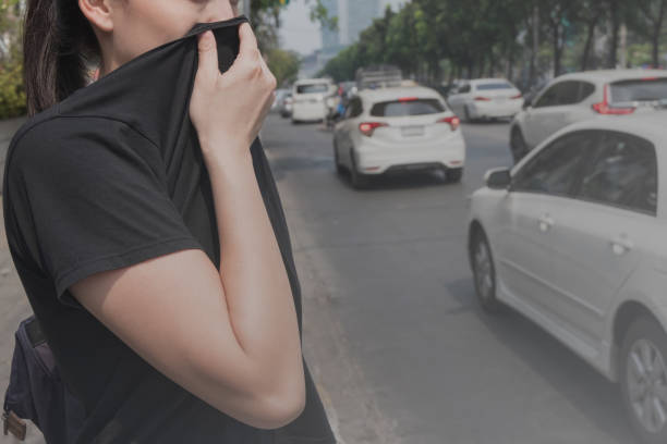 女性は悪い交通汚染のために手で彼女の鼻を閉じます - 大気汚染 ストックフォトと画像