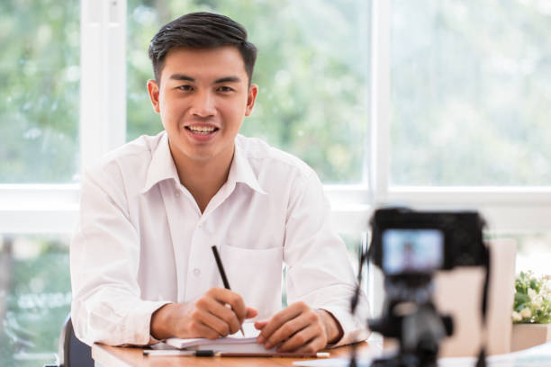istock Happy Asian businessman videoblog / blogger vlogger recording online course or tutorial strategy presentation pass video for teaching live marketing sharing social media channel by mirrorless camera 1130629590