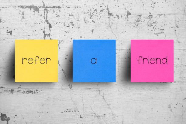 istock Sticky note on concrete wall, Refer a Friend 1130630568