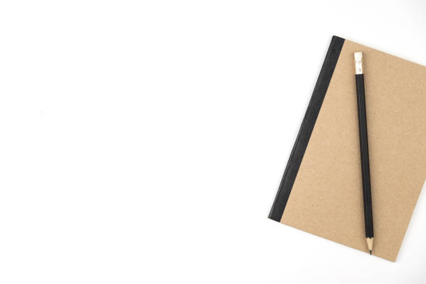 istock Pencil on book of brown on white isolated background 1130631653