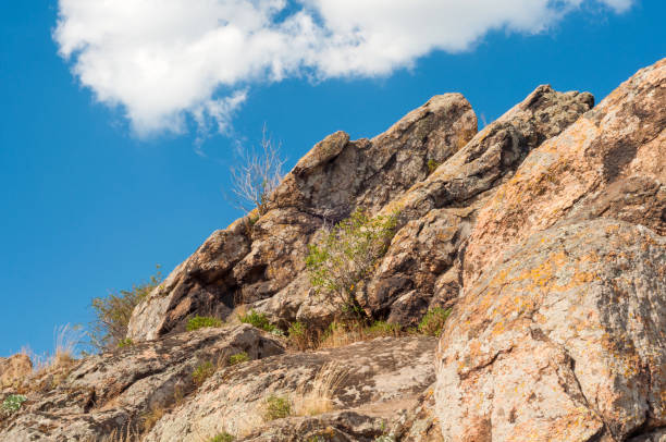 istock Granite rocks covered with grass moss and lichen against the blue sky 1130632845