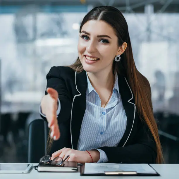 Job interview. Confident headhunter extending welcoming hand. Office workplace.