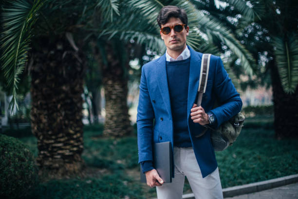 istock Stylish standing businessman at the park 1130635259