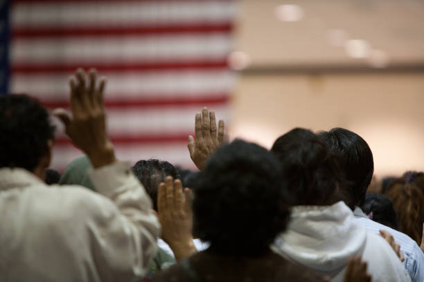 Immigrants at a swearing in ceremony Los Angeles, California, USA - June 22, 2007: Immigrants of many ethnic backgrounds appear at a swearing in ceremony for US citizenship. Photo taken at the US Court's public citizenship ceremony at the LA Convention Center. citizenship stock pictures, royalty-free photos & images