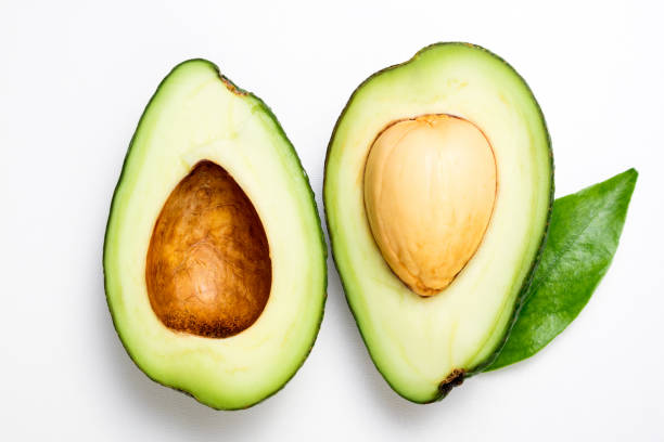 istock Avocado on white background. Tropical abstract background with avocado and leaf. Flat lay, top view 1130640256