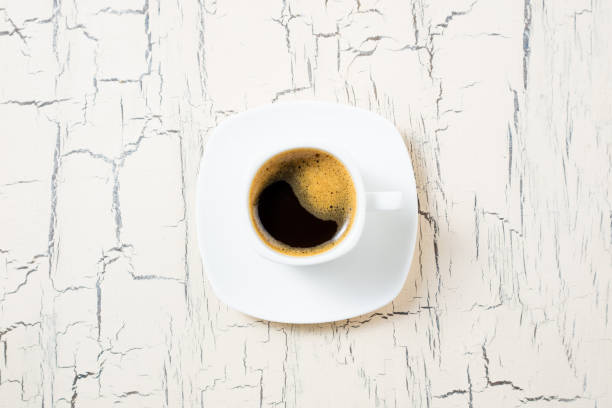 istock Cup of coffee on white kitchen table. Coffee cup espresso for breakfast. Top view, copy space 1130640481