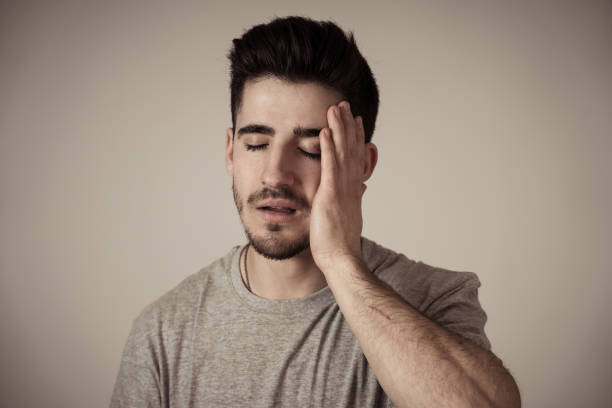 istock Close up portrait of handsome young man crying suffering from depression looking miserable, melancholy and sad isolated on neutral background. In People human face expressions and emotion concept. 1130641464