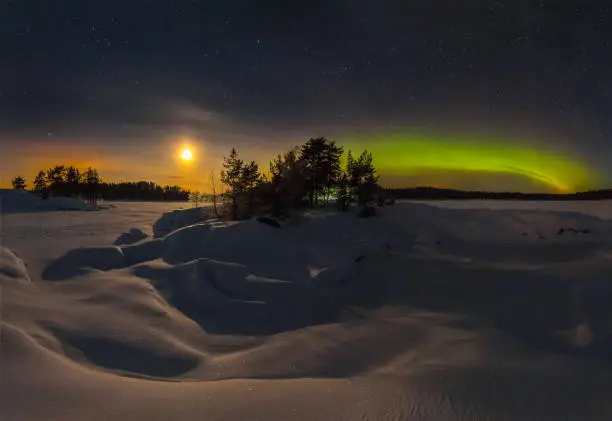 The Northern Lights on Lake Ladoga in the Republic of Karelia. Full moon and northern lights on the lake. Night panoramas.