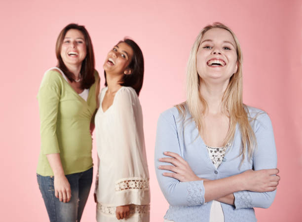 istock Three pretty young women stand together laughing happily 1130642641