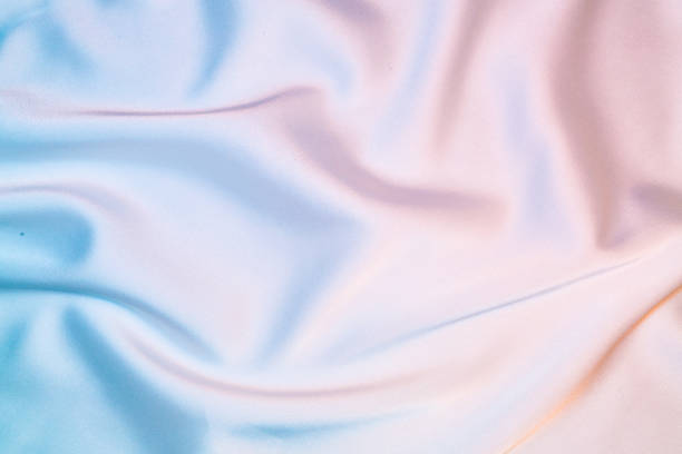 Silk shiny fabric texture in pastel iridescent holographic colors stock photo