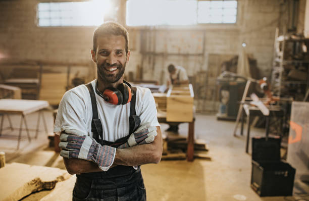 istock Happy manual worker with crossed arms in carpentry workshop. 1130646029