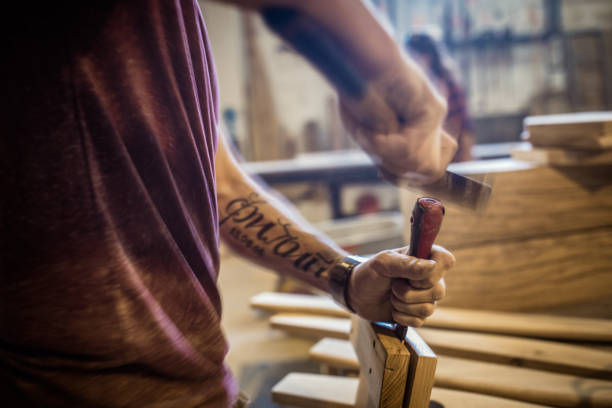 Unrecognizable manual worker working on a piece of wood in carpentry workshop. Blurred motion.