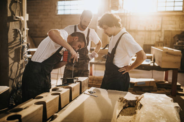 istock Team of manual workers making furniture in carpentry workshop. 1130646985