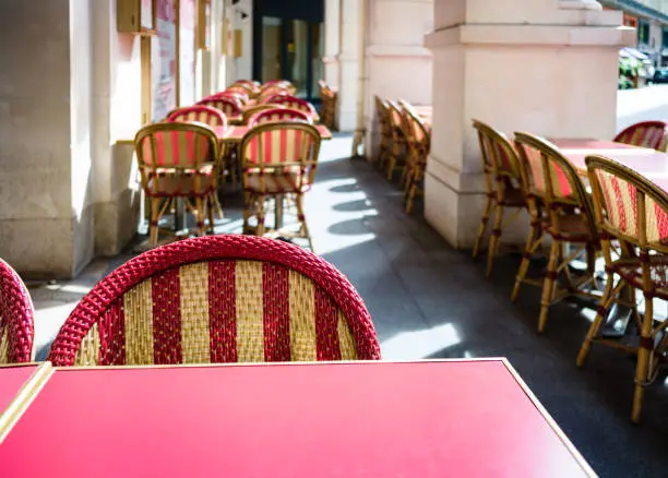 Photo of Typical terrace outside a parisian cafe with rattan chairs.