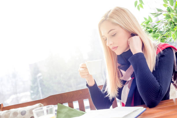 istock Young beautiful woman reading a book in a cafe 1130648654