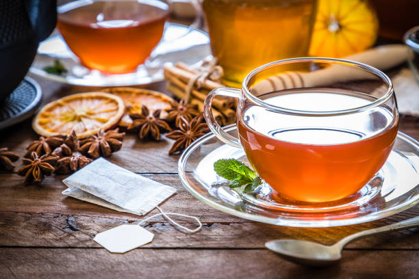 ora del tè: tazza di tè, bastoncini di cannella, anice, arancia secca su tavolo di legno - homewares rustic herbal tea herb foto e immagini stock