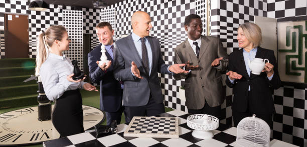 des gens d'affaires souriants résolvant ensemble des énigmes - chess board room business strategy photos et images de collection