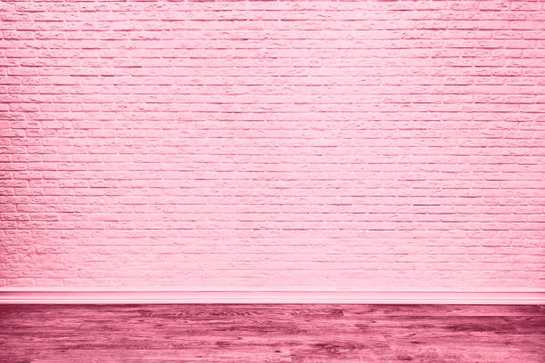 Pink brick wall and plank wood floor.