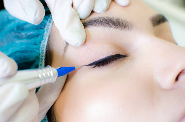 istock Cosmetologist applying permanent make up eyeliner, eyeliner tattoo procedure 1130659263