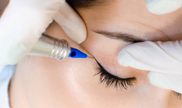 istock Cosmetologist applying permanent make up eyeliner, eyeliner tattoo procedure 1130659282