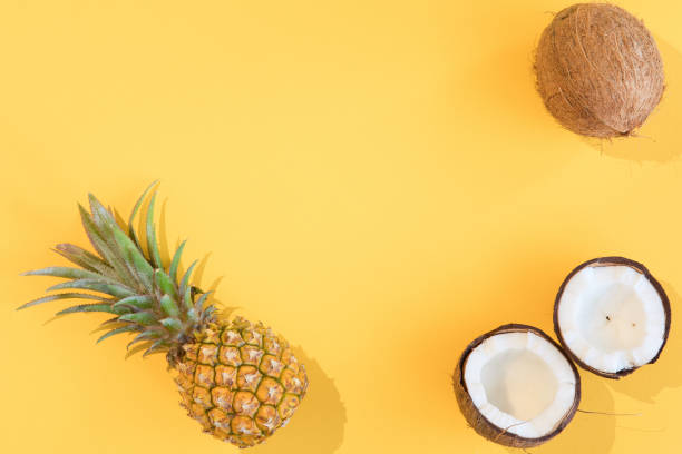 istock Creative layout of pineapple and coconut on yellow background. Flat lay. 1130659360