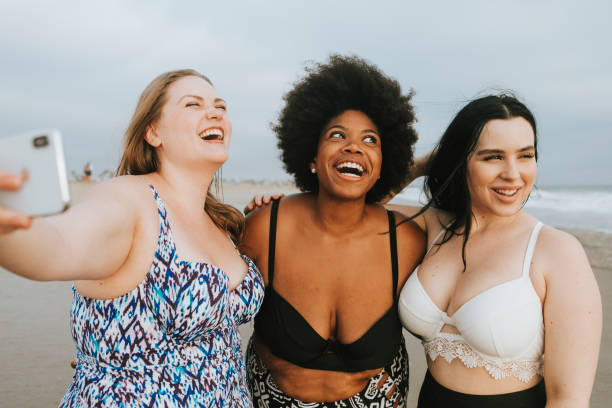 istock Beautiful curvy women taking a selfie at the beach 1130659589