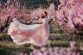 Beautiful young girl under the flowering pink tree