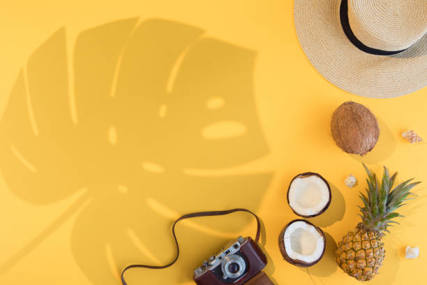 Summer vacation flat lay concept on yellow background. Tropical accessories top view. Space for text.