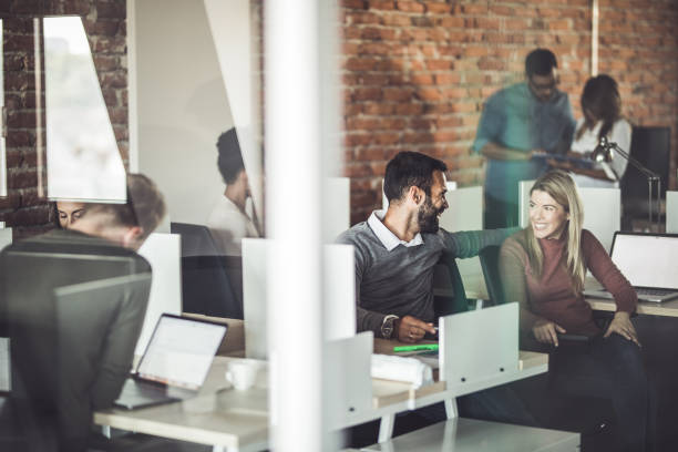 istock Young happy colleagues talking at corporate office. 1130659998