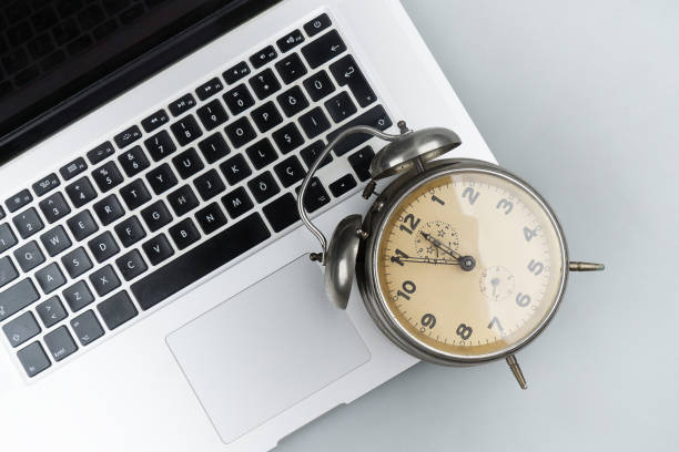 istock Alarm clock on laptop white background 1130660859