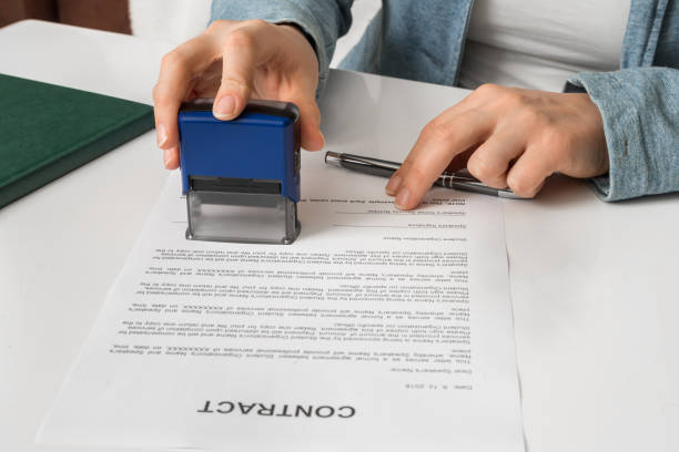 Business woman putting stamp on documents in the office Business woman putting stamp on documents in the office - signing contract concept shorthand stock pictures, royalty-free photos & images