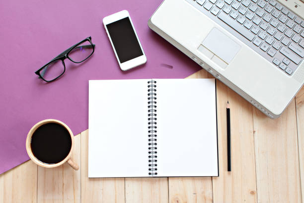istock Top view or flat lay of office table desk work space with blank notebook, smart phone, computer laptop and coffee 1130662636