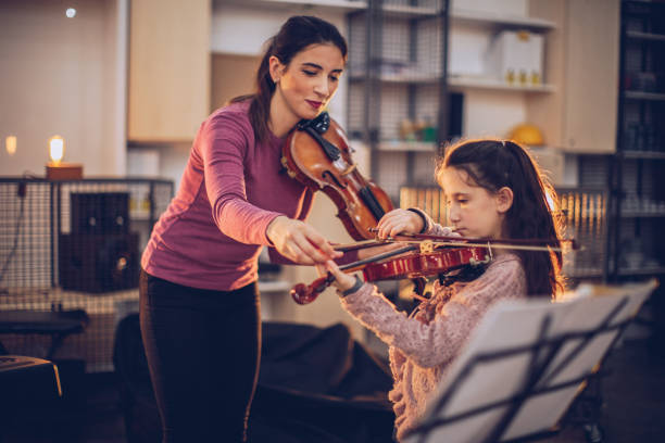 istock Lady violin teacher and girl on class 1130662763