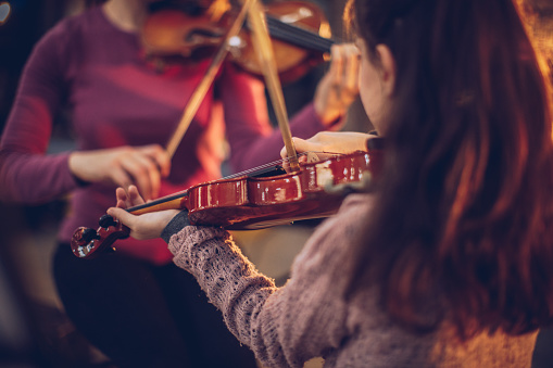 Two people, woman violin teacher working with little boy on violin lessons.