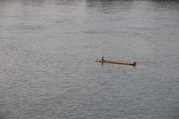 istock fisherman on wooden boat in river 1130666987