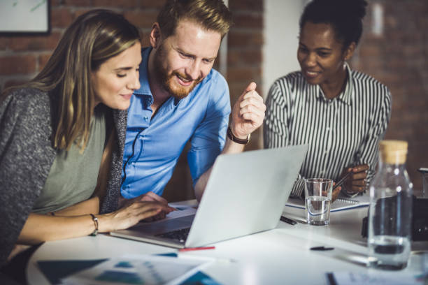 istock Happy business team cooperating while using laptop in the office. 1130668440