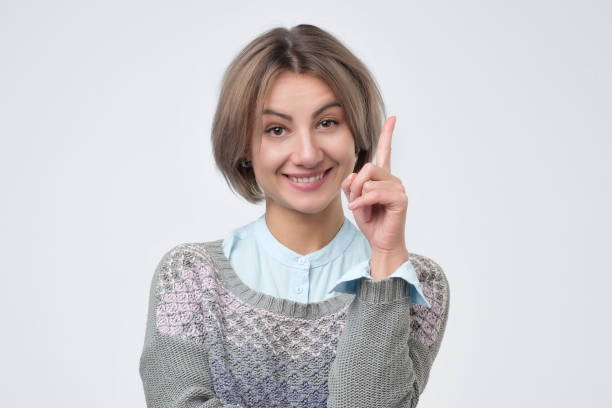 istock Cheerful middle aged woman finding new idea and raising index finger. 1130668499