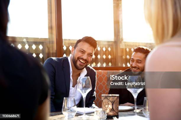 Group Of Multi Ethnic Arab Friends Lunch In A Restaurant In Dubai Stock Photo - Download Image Now