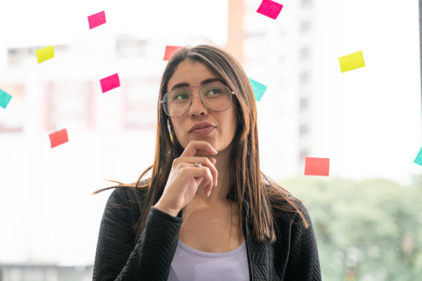 istock Concentrated business woman reading glass wall sticky notes 1130668832